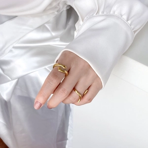 Close-up of dual 18K gold plated rings with elegant organic curved lines and polished finish