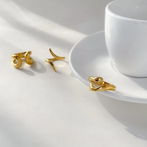 Detailed macro shot of three 18K gold plated minimalist abstract curved open rings