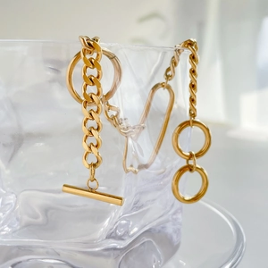 Detailed close-up of a gold geometric chunky chain necklace with T-bar toggle closure
