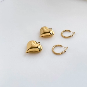 Close-up of polished gold heart-shaped pendants and minimalist hoop earrings set