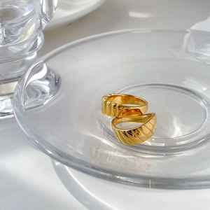 Ensemble de bagues dorées rétro avec rayures verticales et facettes sur coupelle en verre