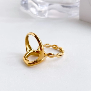 Detail of minimalist gold-plated geometric hollow ring and textured wave band jewelry set