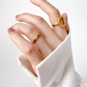Detailed view of layered minimalist gold wavy rings on a model for a modern look