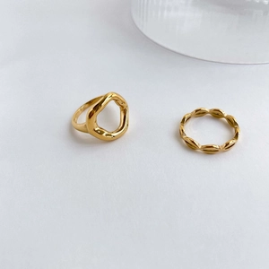 Macro detail of gold-plated wavy ring set with modern minimalist geometric design lines