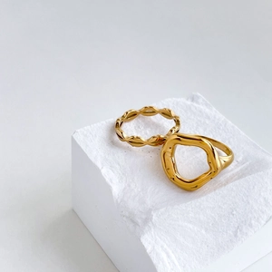 Minimalist gold lip ring set with abstract wave and organic hollow shapes on white stone