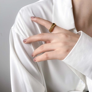 Detailed view of a golden twisted chain ring on a finger with minimalist style