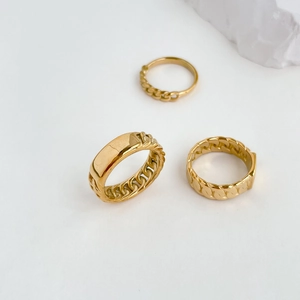 Close-up of minimalist gold chain rings set with polished rectangular plate detail