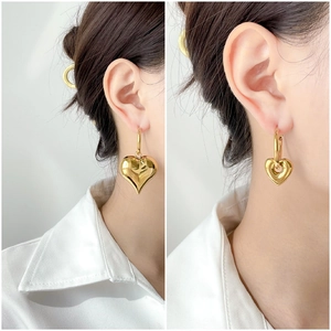 Statement gold heart earrings featuring solid and hollow designs with a polished finish