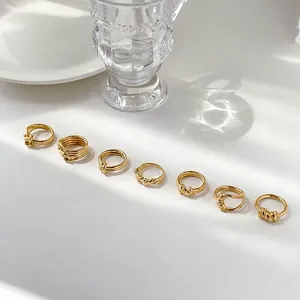 Detailed view of seven minimalist gold knot and twisted rope ring styles labeled A to G