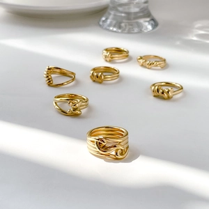 Minimalist gold rope twist ring set with seven unique designs in natural lighting