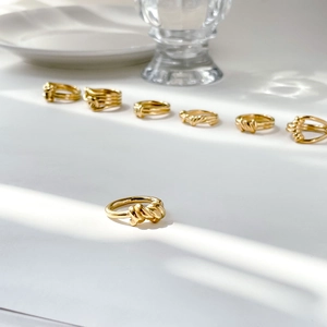 Detailed close-up of several gold twisted rope rings with elegant polished finish