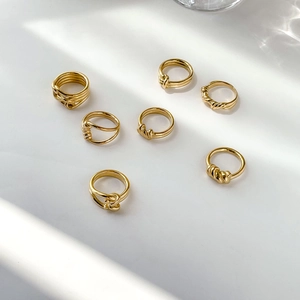 Set of 7 gold minimalist rings featuring twisted rope and knot designs on white background