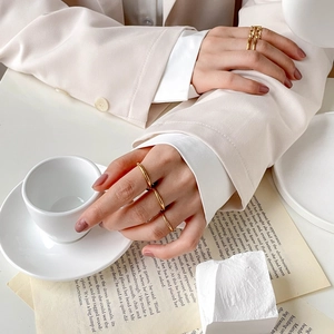 Detail von goldenen Mehrschicht-Ringen am Modell mit Kettengliedern und schlichten Ringen