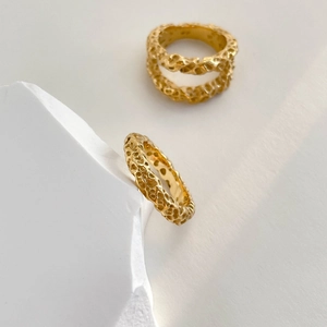 Macro detail of gold crater ring featuring unique lava texture and minimalist artistic design