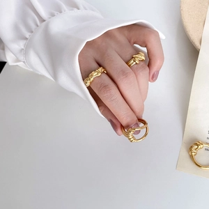 Detailed view of gold twisted rope ring on model finger with elegant minimalist aesthetic