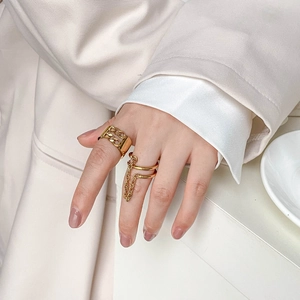 Goldene mehrlagige Gliederkettenringe mit Fransen-Design an einer Hand gezeigt
