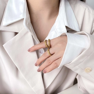 Detailed view of a gold crater lava ring with irregular textured metal surface on a hand