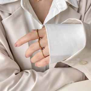 Nahaufnahme der goldenen ineinandergreifenden Dreifachringe zu elegantem Business-Outfit