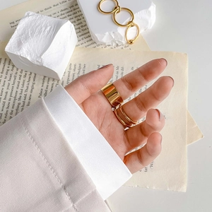 Details eines goldfarbenen Mehrschichtrings mit Dreifachbändern und schickem Kettendesign