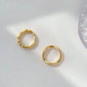 Detailed view of two vintage gold-plated rings with wave texture and smooth finish