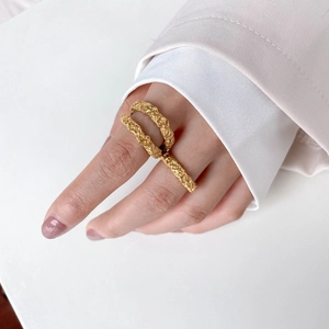 Double-layered gold crater rings with irregular hammered texture worn by a model