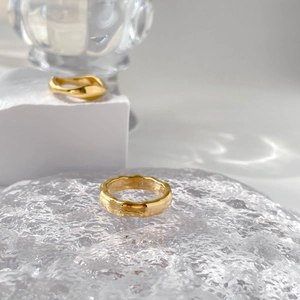 Detailed view of two irregular gold rings with textured molten design on ice base