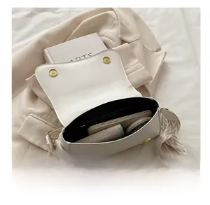 Interior view showing the capacity of a beige leather crossbody bag with jacquard strap