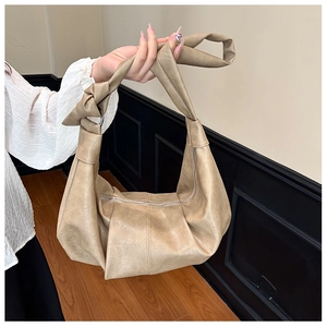 Detail of light khaki soft PU leather hobo bag with knotted strap and metal zipper