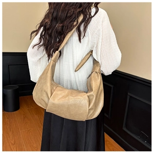 Detail of soft leather hobo bag with adjustable strap and central stitching detail