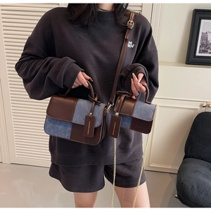 Detail of retro leather and blue denim patchwork handbags with elegant chain strap