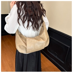 Close-up of beige pleated moon bag showing crinkle leather texture and large capacity design