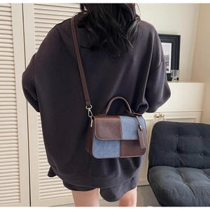 Detail showing vintage brown leather and blue denim patchwork small crossbody bag