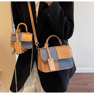 Close-up of retro brown faux leather and blue denim stitching on crossbody bags