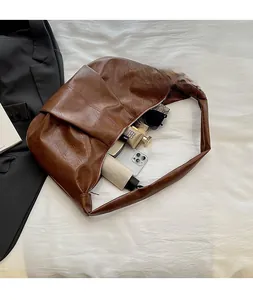 Detailed interior of brown hobo bag showing large capacity for essentials like sunglasses