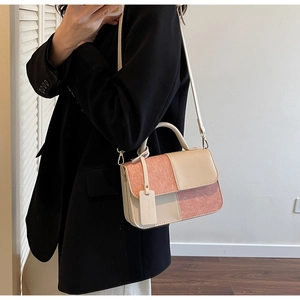 Detail of pink and white patchwork crossbody bag with pearlescent finish and gold hardware