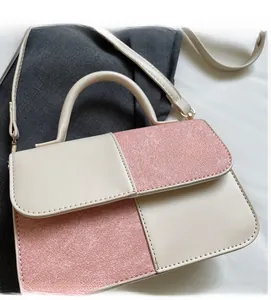 Detail of color-block mini bag showing cream faux leather and glitter pink fabric texture