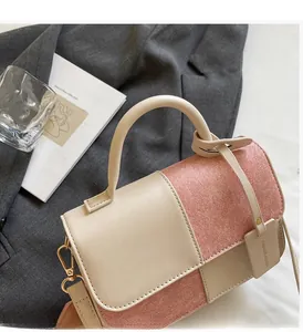 Detail of elegant two-tone faux leather handbag with gold hardware and fashion tag