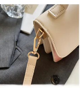 Close-up of bright gold hardware and fine leather texture on contrast color handbag
