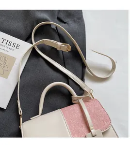 Close-up of contrast color handbag with pink glitter flap and adjustable shoulder strap
