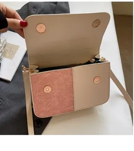Detail of crossbody bag showing beige leather, pink suede texture and magnetic closure