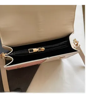 Detailed interior of contrast color crossbody bag showing smooth golden zipper and lining