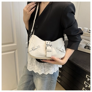 Detail of white crocodile embossed texture and silver buckle on chic underarm bag