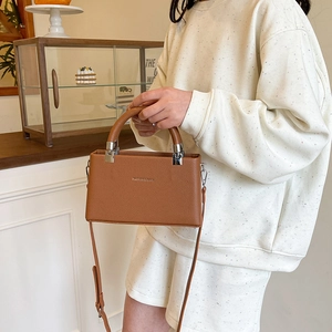 Elegant brown lychee pattern leather satchel with top handle and crossbody strap