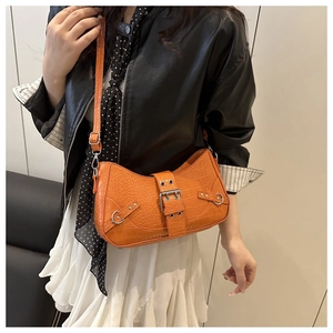 Detail of orange faux crocodile skin bag with silver buckles and adjustable strap