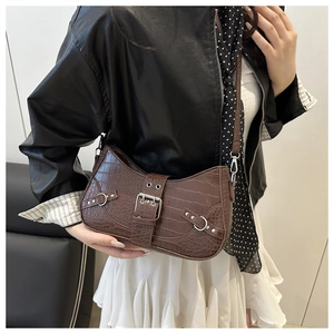Detailed shot of brown crocodile pattern shoulder bag with silver buckle and strap