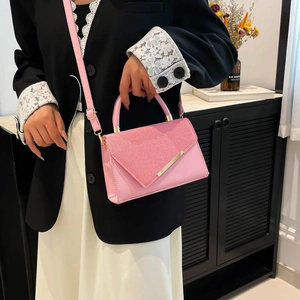 Pink luxury textured crossbody bag with gold hardware and elegant circular handle