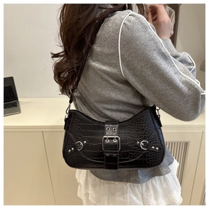 Detail of black crocodile texture shoulder bag with silver buckle and metal rivets