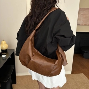 Vintage dark brown leather hobo bag with slouchy pleated design on female model