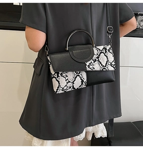 Detail of snake print and black lychee leather contrast on a modern lady crossbody bag
