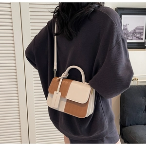 Detail of rhombic quilted crossbody bag in beige and brown leather with fashion tag